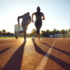 Deux coureurs sur une piste, le soleil couchant projette leurs ombres. Ils s'entraînent, peut-être pour savoir que veut dire EF en course à pied.