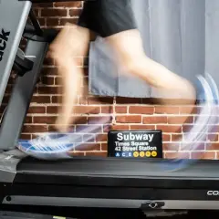 Person en mouvement sur un tapis roulant NordicTrack, simulant des gammes athlétiques. Un panneau "Subway Times Square" est visible.