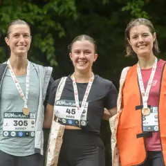 Trois coureuses souriantes, médailles au cou, célèbrent leur participation à la course RUN for PLANET.