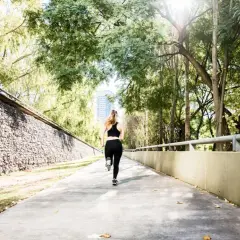 Une femme court sur un chemin ensoleillé, s'entraînant pour le semi marathon Venise.