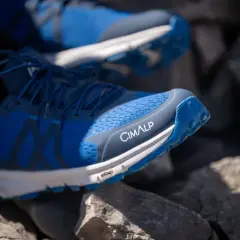 Chaussures de trail bleues CIMALP sur des rochers, parfaites pour le meilleur trail sportif.