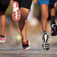 Des coureurs en action, leurs pieds frappant le sol. L'un d'eux montre une foulée pronatrice, un mouvement naturel pour certains.