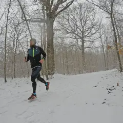 Un coureur s'entraîne sur un sentier enneigé, profitant d'une course hivernale près de Saint-Étienne, Lyon.