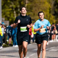 Deux coureurs souriants participent au semi marathon de Madrid, le numéro 1109 et le 1041.