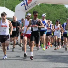 Course à pied en Île-de-France, des coureurs franchissent une arche de départ. L'un d'eux porte le dossard 113.