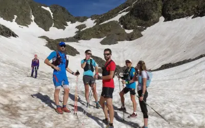 Une équipe de trail sur un sentier enneigé en montagne, profitant d'une journée ensoleillée.