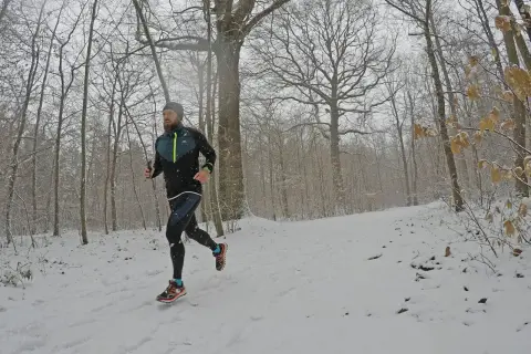 Un coureur s'entraîne sur un sentier enneigé, profitant d'une course hivernale près de Saint-Étienne, Lyon.