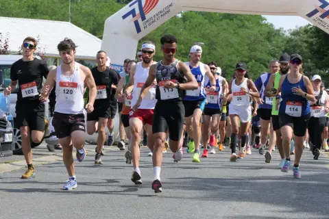Course à pied en Île-de-France, des coureurs franchissent une arche de départ. L'un d'eux porte le dossard 113.