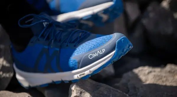 Chaussures de trail bleues CIMALP sur des rochers, parfaites pour le meilleur trail sportif.