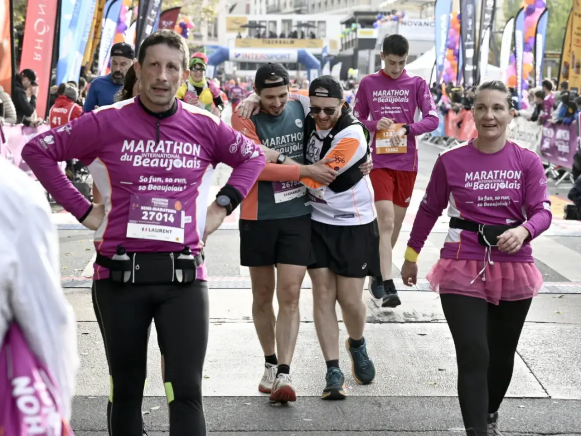 Des coureurs franchissent la ligne d'arrivée du marathon du Beaujolais. Le dénivelé a été un défi, mais l'ambiance est à la fête.