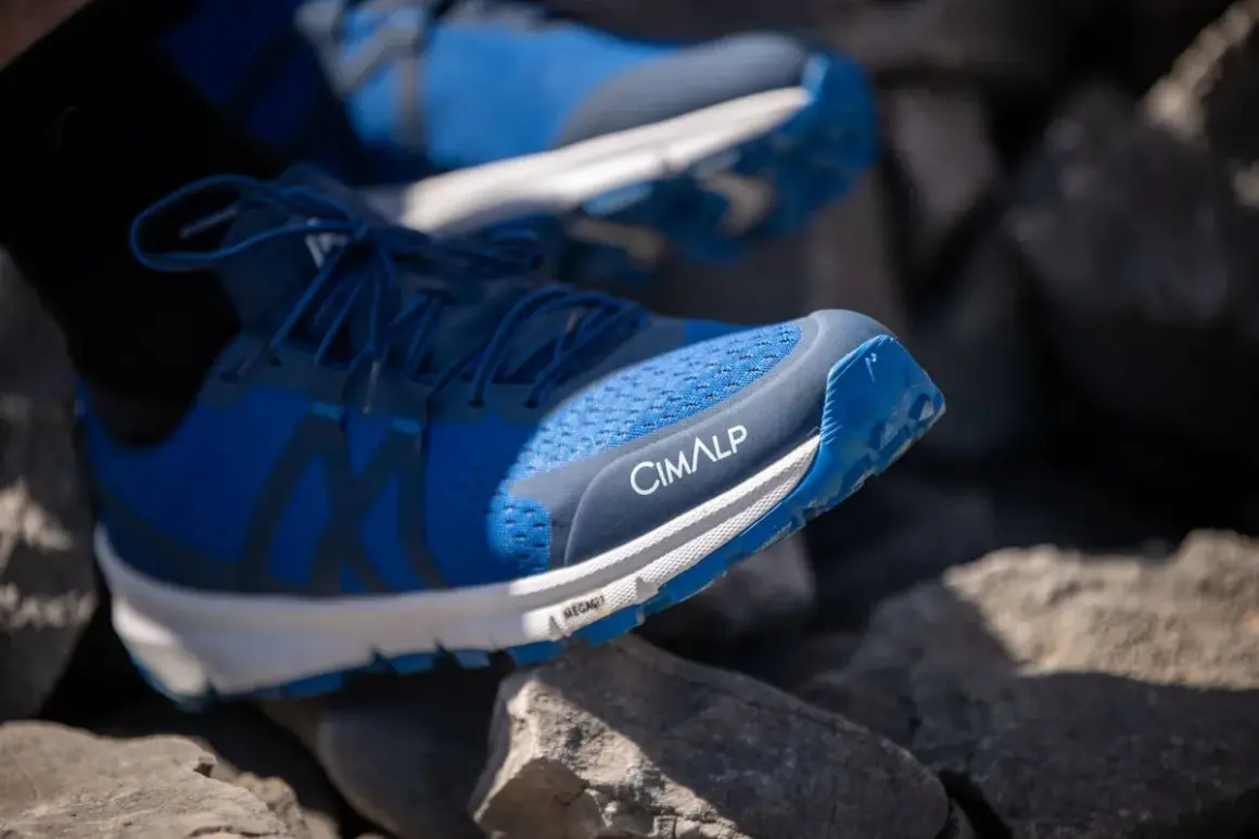 Chaussures de trail bleues CIMALP sur des rochers, parfaites pour le meilleur trail sportif.