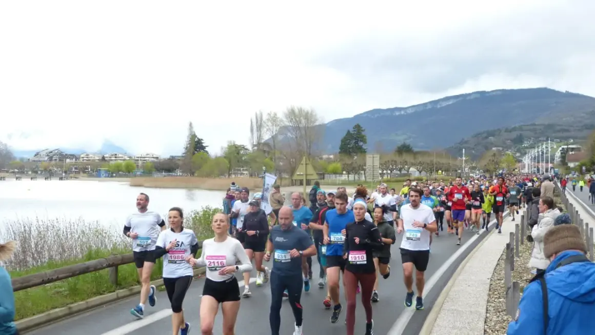 Course à Aix-les-Bains : une foule de coureurs participe à un marathon au bord du lac, avec des montagnes en toile de fond.
