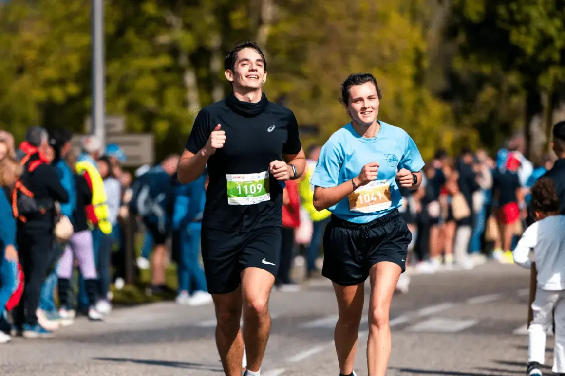 Deux coureurs souriants participent au semi marathon de Madrid, le numéro 1109 et le 1041.