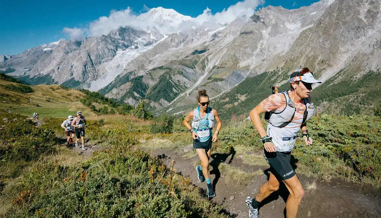 Coureurs en pleine course de trail, atteignant leur poids de forme dans un paysage montagneux spectaculaire.