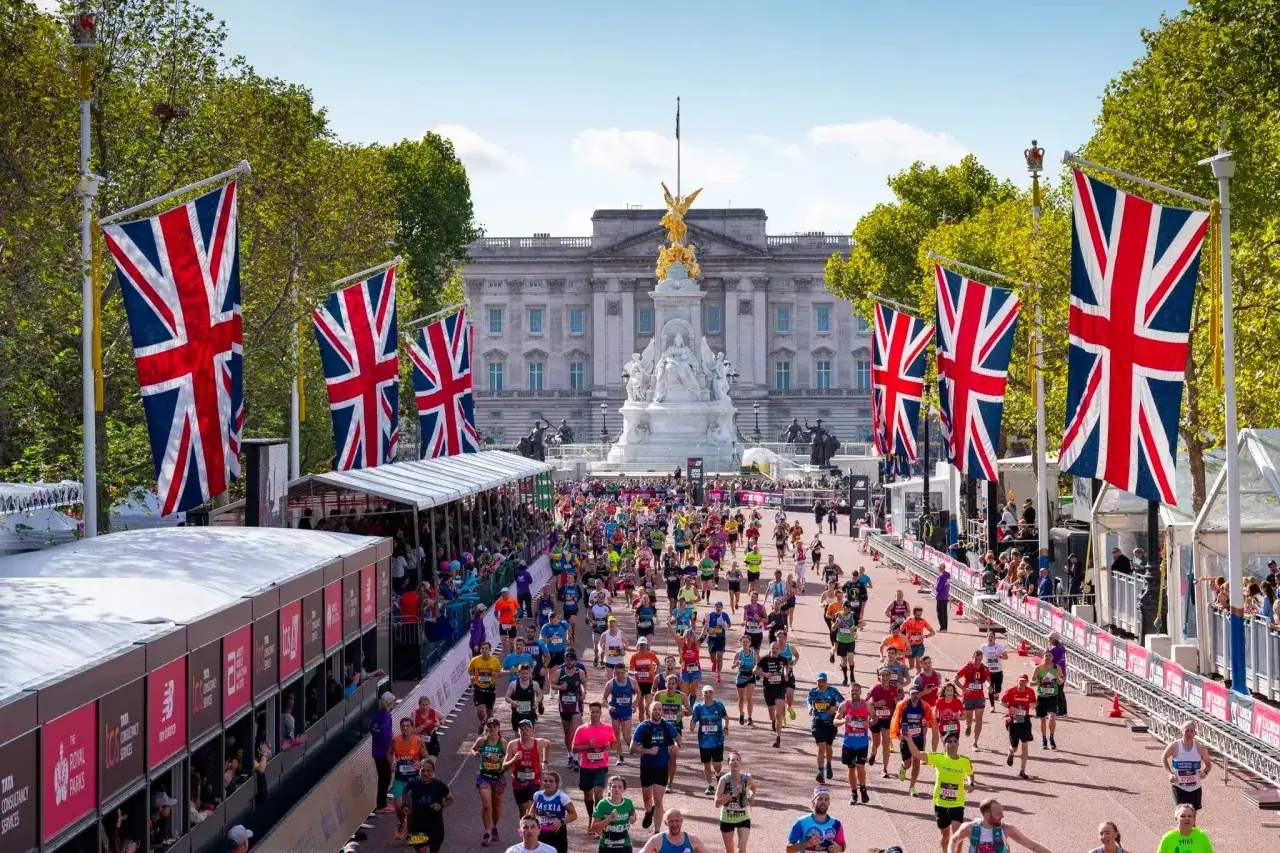 Des milliers de coureurs traversent Londres, drapeaux britanniques flottant, lors du marathon de Londres.