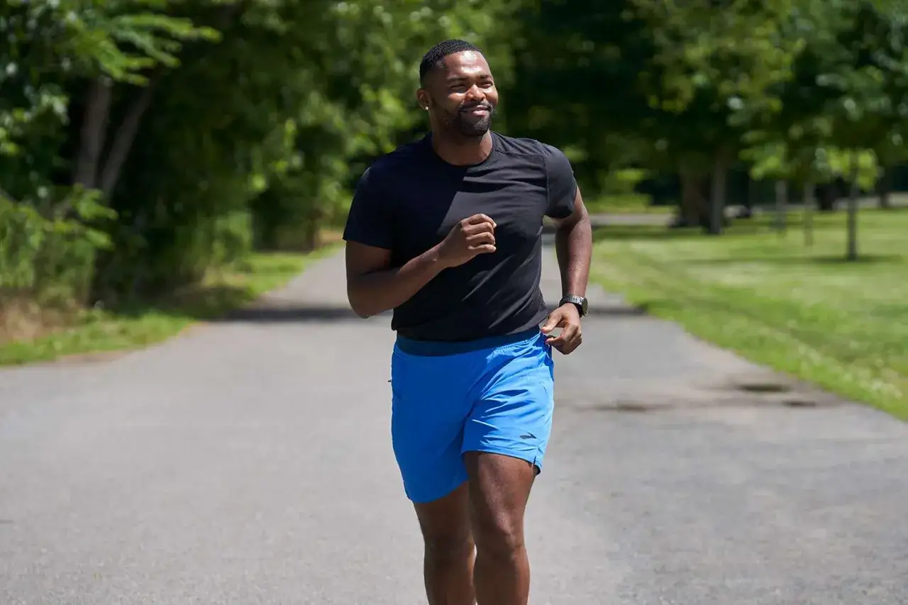 Un homme court dans un parc. Il se demande combien de km courir par semaine pour maigrir.