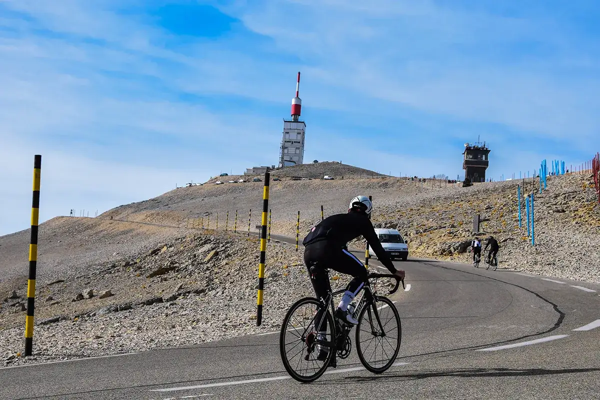 Cycliste en plein effort lors du semi-marathon du Mont Ventoux, avec la tour de télécommunication en arrière-plan.