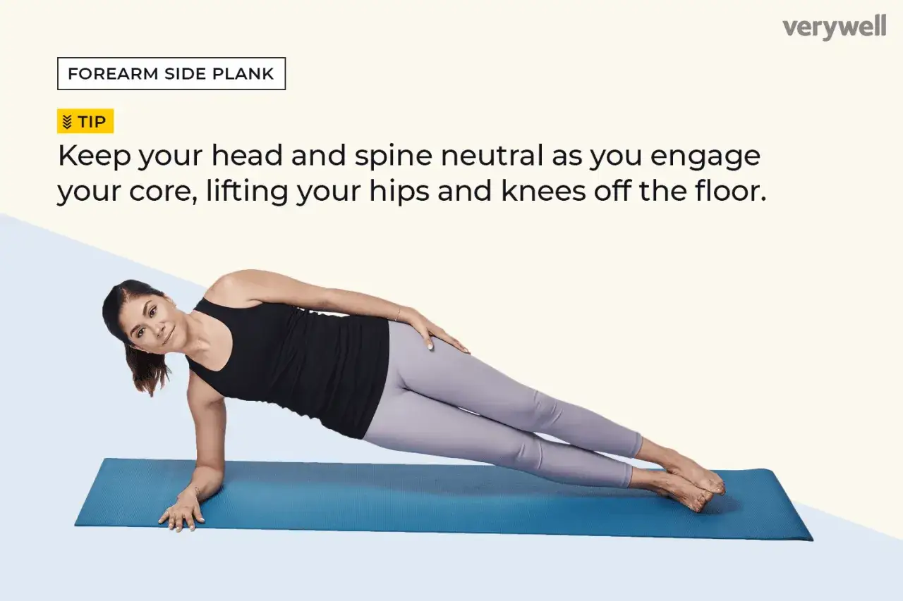 Femme effectuant un gainage lat&eacute;ral sur un tapis bleu, le corps align&eacute; sur les avant-bras et les pieds.
