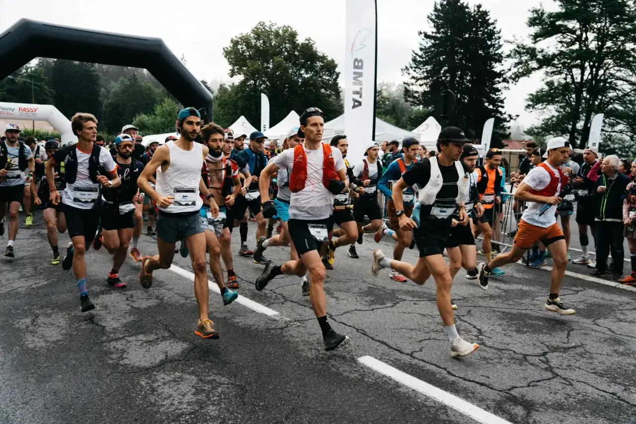 Des coureurs s'&eacute;lancent au d&eacute;part du trail des Fiz, sous une arche noire, pr&ecirc;ts &agrave; affronter le parcours.