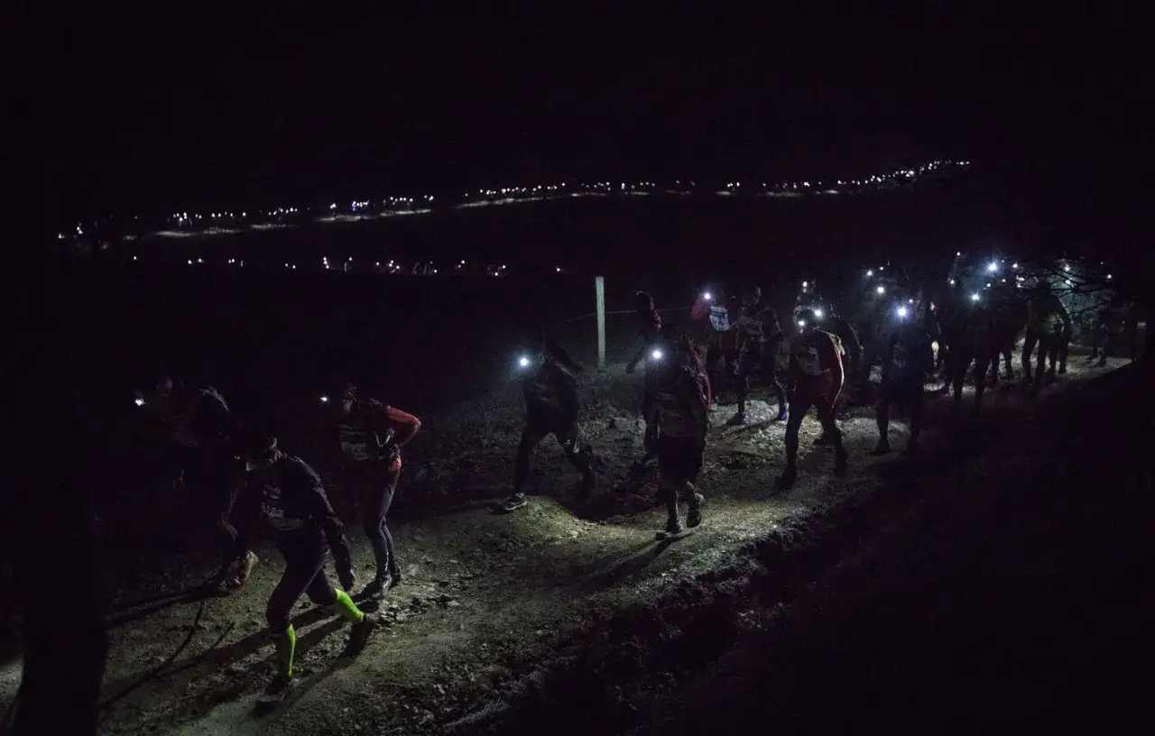 Course de trail nocturne, des coureurs illuminent le chemin avec leurs lampes frontales sur le trail Saint-&Eacute;tienne Lyon.