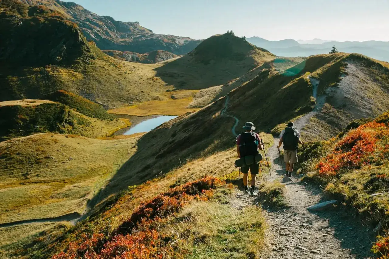 Deux randonneurs sur le tour des Fiz trail, profitant d'un paysage montagneux aux couleurs d'automne.